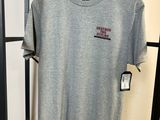 un t-shirt gris suspendu à un portant dans un magasin de vêtements