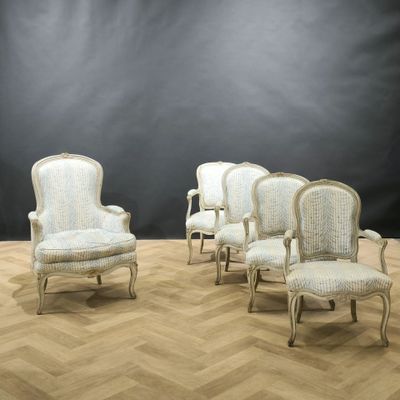 four chairs in a room with a black wall and a wooden floor