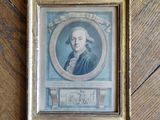 une vieille photo représentant un homme en manteau bleu, assis devant un parquet