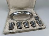 a silver plate with six cups in it in a case