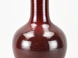 a red vase that is sitting on a white surface