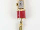 an image of a red and gold watch with a tassel hanging from it ' s side