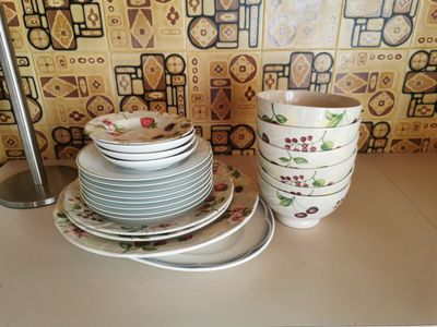 a stack of plates and cups sitting on a counter