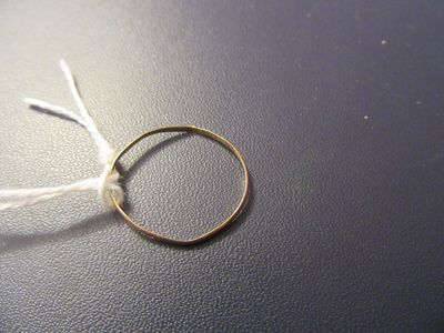 une bague en or à laquelle est attaché un cordon blanc