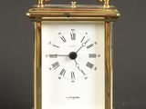 une horloge de voyage ancienne en laiton, avec des chiffres romains sur le cadran