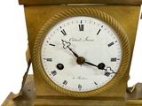 a gold clock with roman numerals on the face