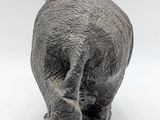 a statue of an elephant that is walking on a white surface