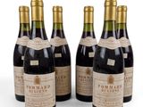 six bouteilles de vin sont alignées sur une surface blanche