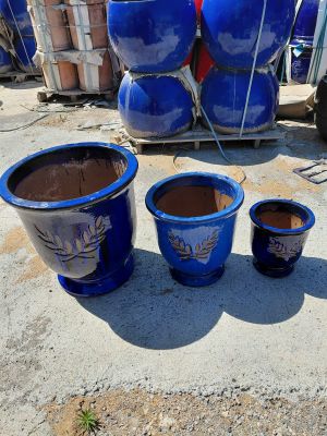 three blue pots sitting next to each other on the ground
