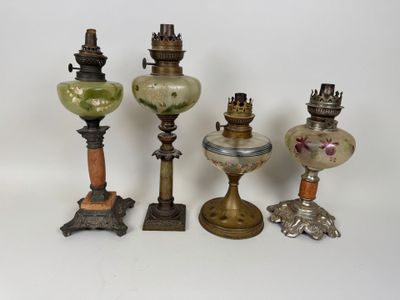 several antique lamps are lined up on a white surface
