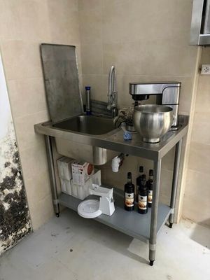 a kitchen with a sink and a counter with a lot of stuff on it