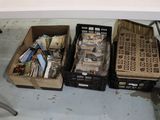 Plusieurs cartons contenant des objets divers sont posés sur une table devant une chaise.