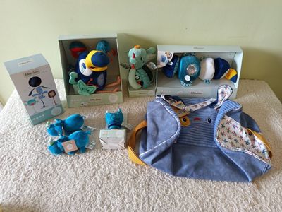 several stuffed animals are sitting on a table next to two boxes of toys