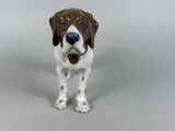 a figurine of a brown and white dog on a gray surface
