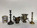 many different types of candles and vases on the table