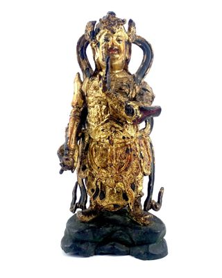 une statue en or représentant une femme tenant un serpent