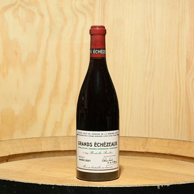 a bottle of wine sitting on top of a barrel