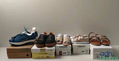several pairs of shoes sitting on top of boxes on a table