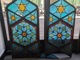 une paire de vitraux ornés de motifs géométriques, placés devant une fenêtre
