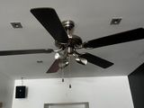 un ventilateur de plafond suspendu au plafond d'une pièce