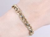 a close up of a person ' s hand wearing a gold chain bracelet
