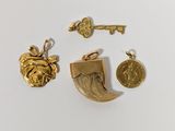 trois bijoux en or, dont une clé, une pièce de monnaie et un pendentif