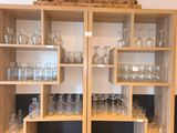 de nombreux verres, les uns à côté des autres, sur les étagères de la pièce