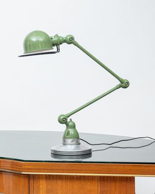 a green lamp that is on top of a desk