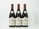 trois bouteilles de vin rouge posées sur une table blanche
