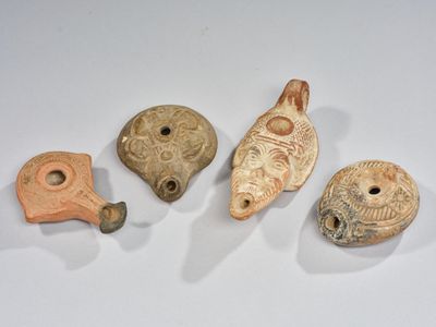 Plusieurs pièces de poterie sont exposées sur un fond blanc