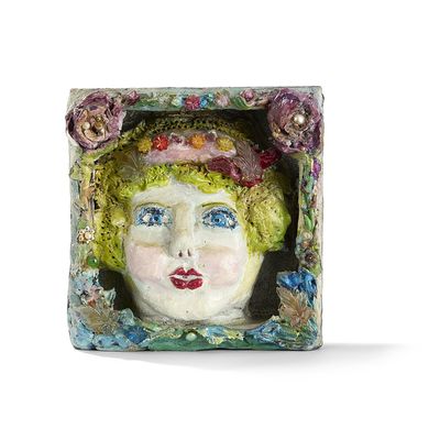une sculpture en céramique représentant une femme coiffée d'un chapeau