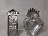 pair of silver heart shaped spoons on display in a glass case