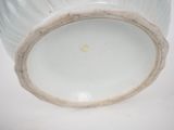 a white vase with a brown rim sitting on a table