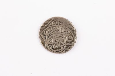 a close up of a silver coin on a white surface