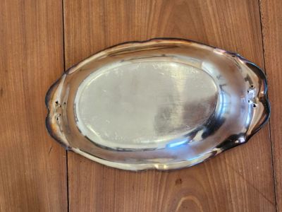 a silver platter on a wooden table with a spoon