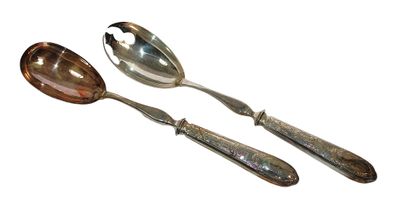 two spoons and a spoon rest on a white surface