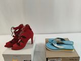 pair of red high heeled shoes sitting on top of a box