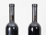 two bottles of wine sitting next to each other on a table