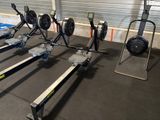 several rowing machines are lined up in a row in a gym