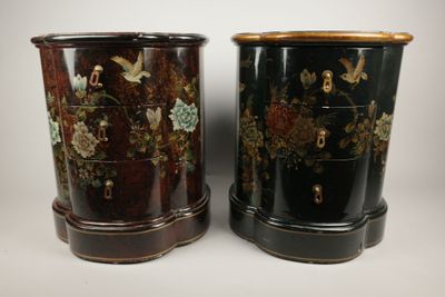 pair of black and gold decorated vases sitting on top of each other