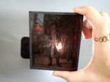 a person holding up a picture of a person with a candle