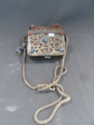 un vieux sac à main entouré d'une corde, posé sur une table