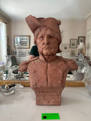 a bust of a man with a hat on a table