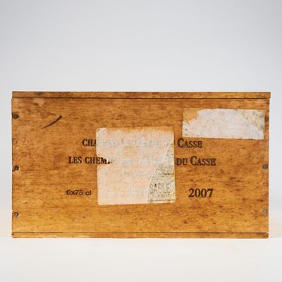 une vieille boîte en bois avec une étiquette posée sur une surface blanche