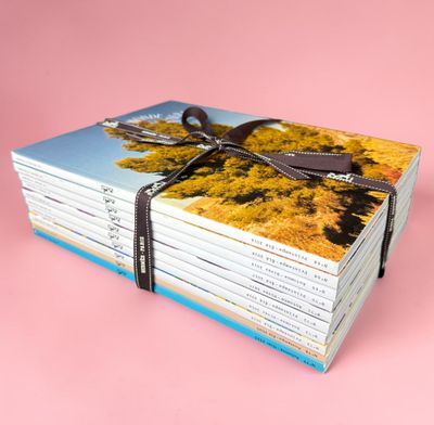 des livres empilés les uns sur les autres sur une surface rose