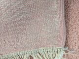 a close up of a pink blanket with fringes on it