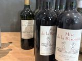 plusieurs bouteilles de vin sont alignées sur une table en bois