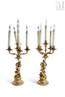 pair of antique brass candelabs with candles on each of them