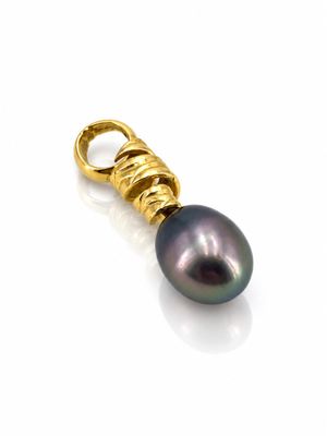 un pendentif en perle noire et or sur fond blanc