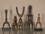 cinq figurines en bois posées sur une table en verre